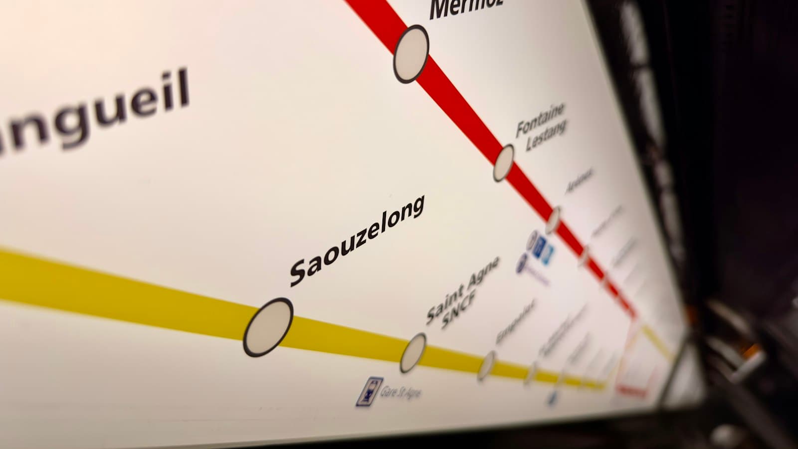 Close-up of a backlit metro map with red and yellow lines connecting labelled station circles