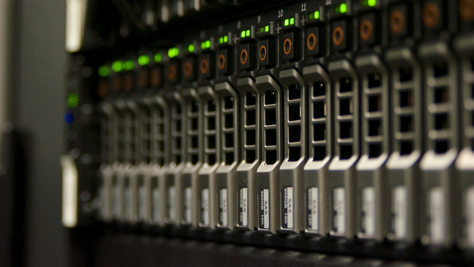 Close-up of a row of server drive bays with green and orange status lights